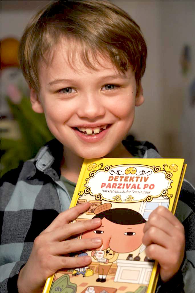 Kind mit aufgeklappten Parzival PO Buch