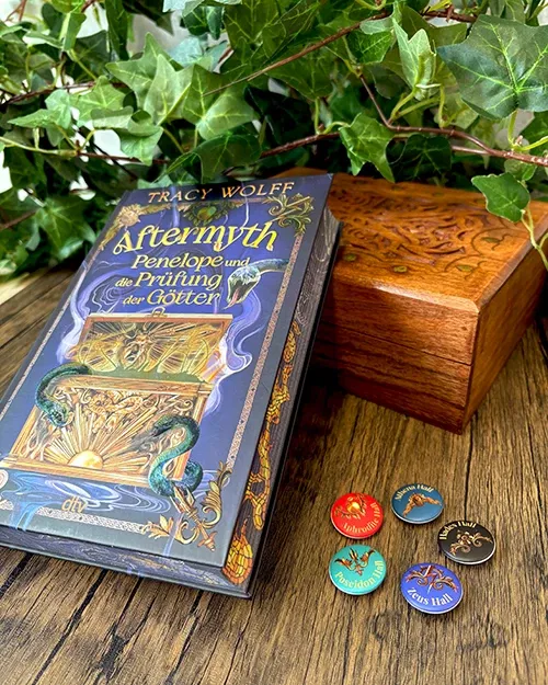 Gewinnspielpreise: Buch Aftermyth von Tracy Wolff mit Farbschnitt, 5 Ansteckbuttons und ein Schmuckkästchen aus Holz