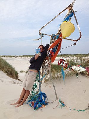 Krischan Koch am Strand mit seinem Buch