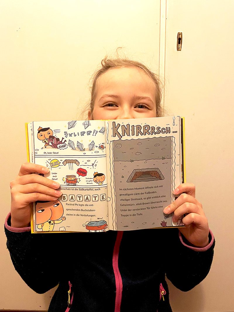 Kind mit aufgeklappten Parzival PO Buch